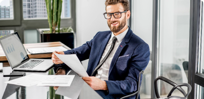 portrait-handsome-banker-working-with-laptop-sitting-luxury-office-interior-with-beautiful-view-skyscrapers.png
